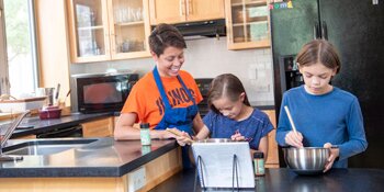Student and children baking in a kitchen.