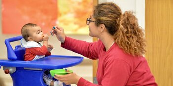 Student feeding a baby.