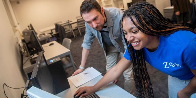Instructor helping a student on a computer