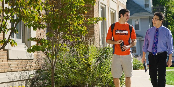 Professor Aaron Ebata walks with student Jeremy Kanter outside Doris Kelley Christopher Hall after a class.