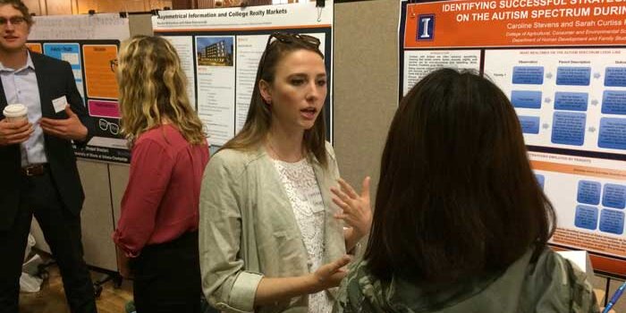 HDFS student explaining a poster to another person