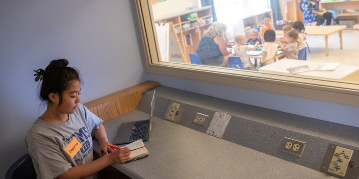 Student observing a classroom through a glass window