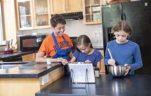 Student working with two children in a kitchen